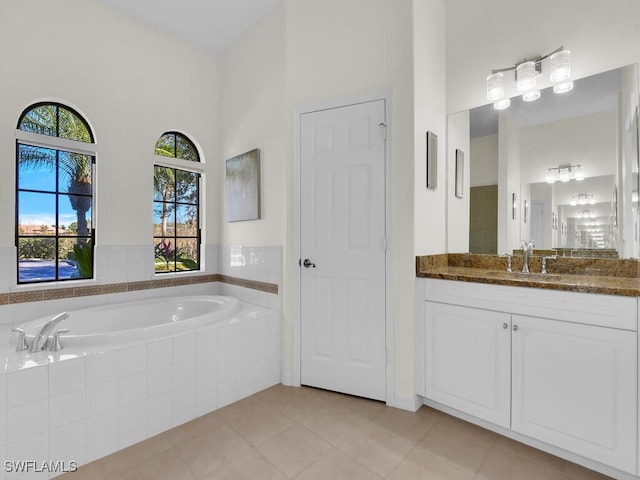 bathroom featuring tile patterned floors, tiled bath, a towering ceiling, and vanity