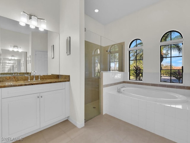 bathroom with tile patterned floors, vanity, and plus walk in shower