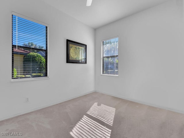 carpeted spare room with ceiling fan