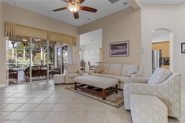 tiled living room featuring beamed ceiling, high vaulted ceiling, and ceiling fan