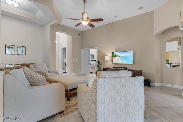 living room with ceiling fan, light tile patterned flooring, and ornamental molding