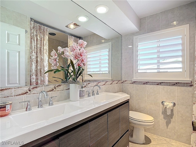 bathroom featuring a healthy amount of sunlight, toilet, and tile walls