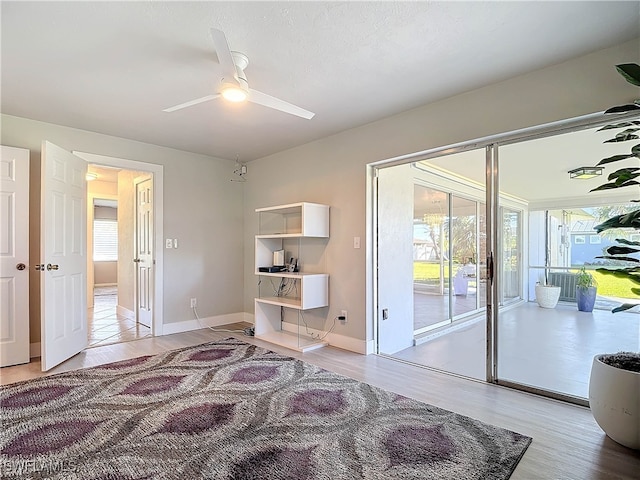 bedroom with ceiling fan, access to exterior, wood-type flooring, and a textured ceiling