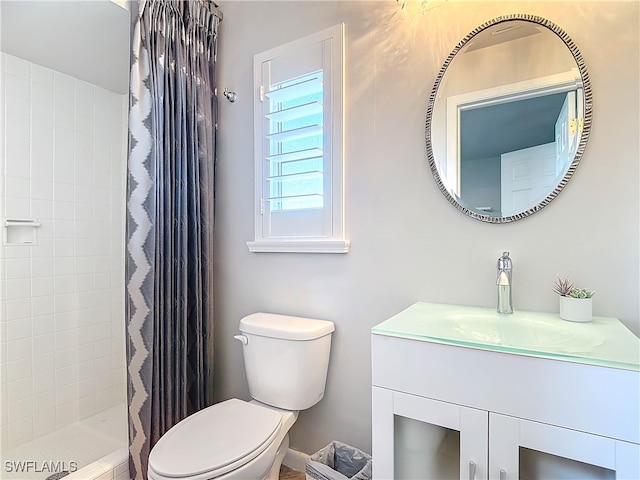 bathroom featuring vanity, toilet, and walk in shower