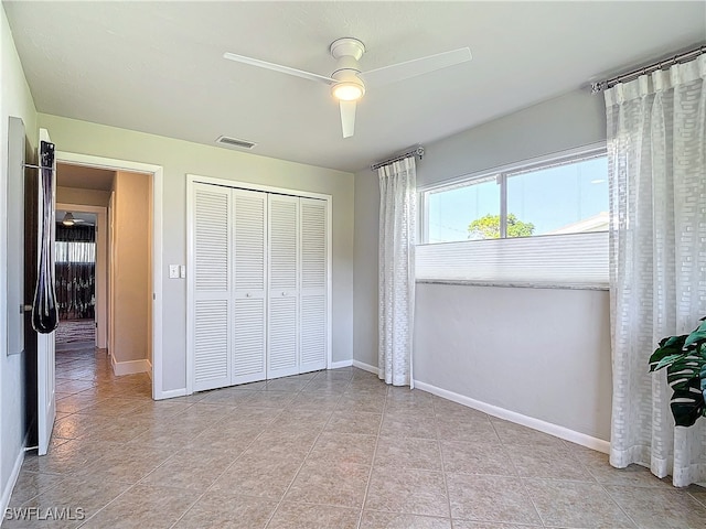 bedroom featuring ceiling fan, light tile patterned floors, and a closet