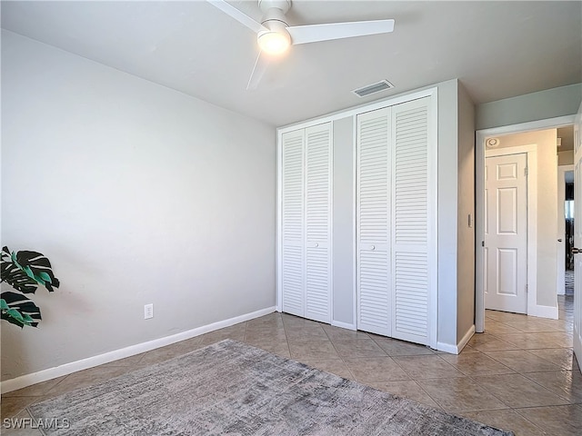 unfurnished bedroom with ceiling fan and light tile patterned flooring