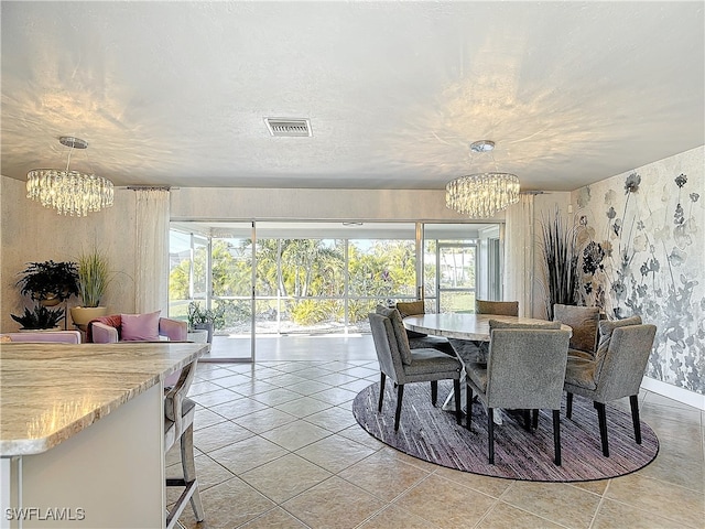 tiled dining area with a chandelier and a textured ceiling