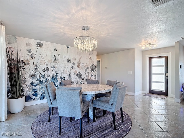 tiled dining space featuring a textured ceiling and an inviting chandelier