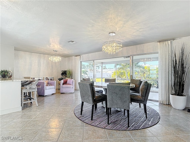 dining room featuring a chandelier and a textured ceiling