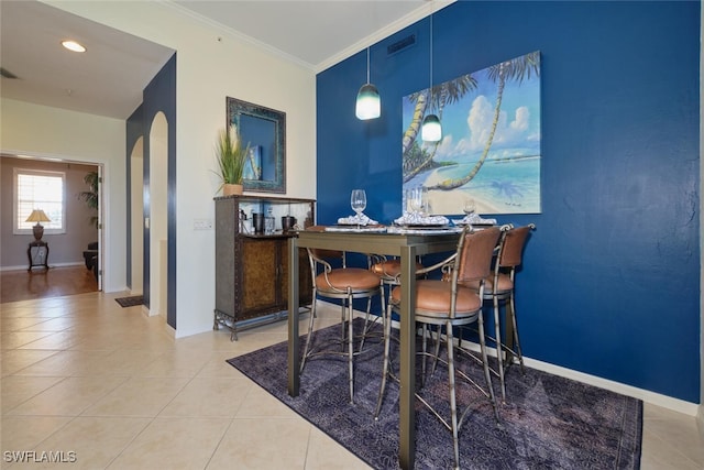 tiled dining area featuring ornamental molding