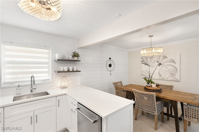 kitchen with white cabinetry, sink, an inviting chandelier, kitchen peninsula, and decorative light fixtures