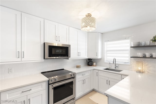 kitchen with sink, white cabinetry, stainless steel appliances, and tasteful backsplash