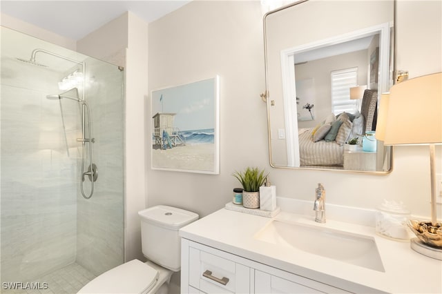 bathroom with tiled shower, vanity, and toilet