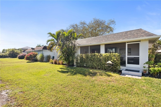 view of front of house with a sunroom and a front yard