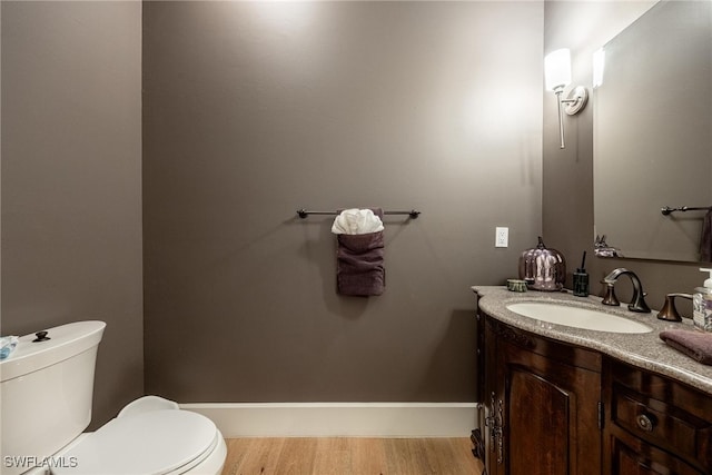 bathroom featuring hardwood / wood-style flooring, vanity, and toilet