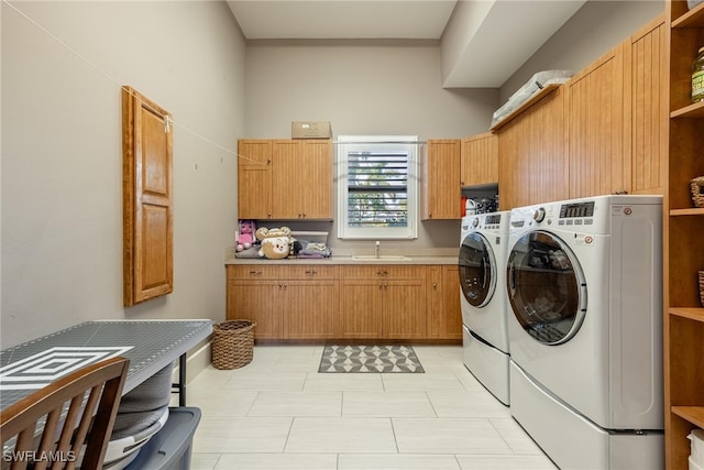 washroom with washing machine and clothes dryer, sink, and cabinets