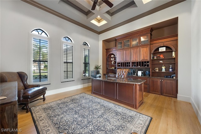 office area featuring a towering ceiling, ornamental molding, coffered ceiling, ceiling fan, and light hardwood / wood-style flooring