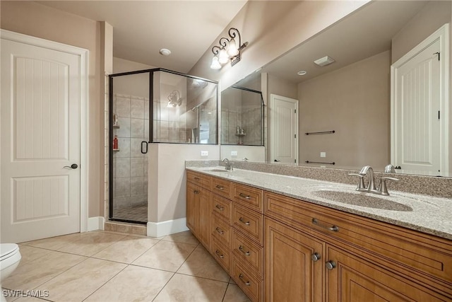 bathroom with tile patterned floors, a shower with door, vanity, and toilet