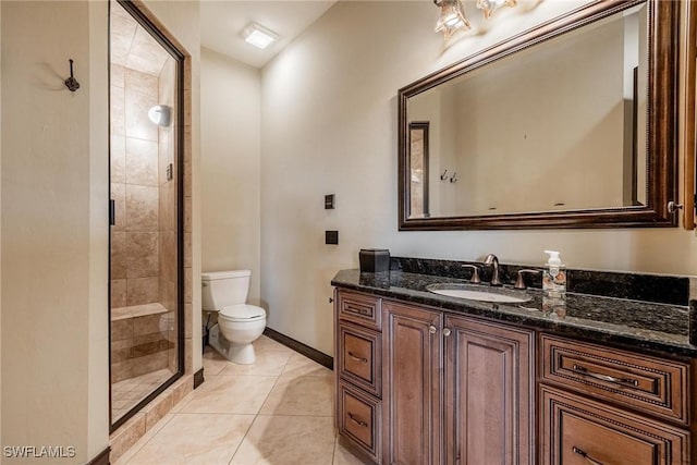 bathroom with tile patterned floors, vanity, an enclosed shower, and toilet