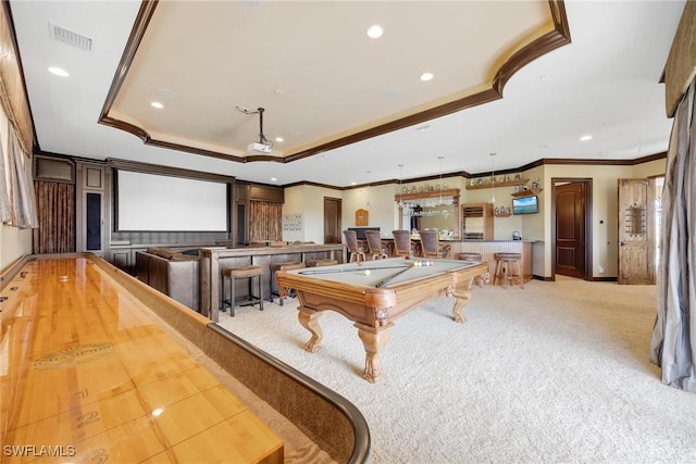 game room with light colored carpet, a tray ceiling, crown molding, billiards, and bar