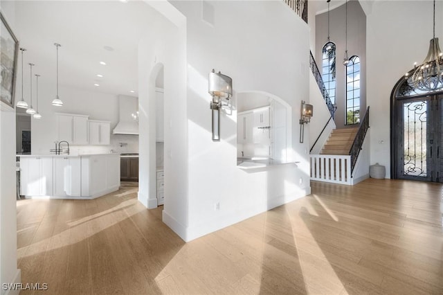 foyer entrance with light wood-type flooring and a high ceiling