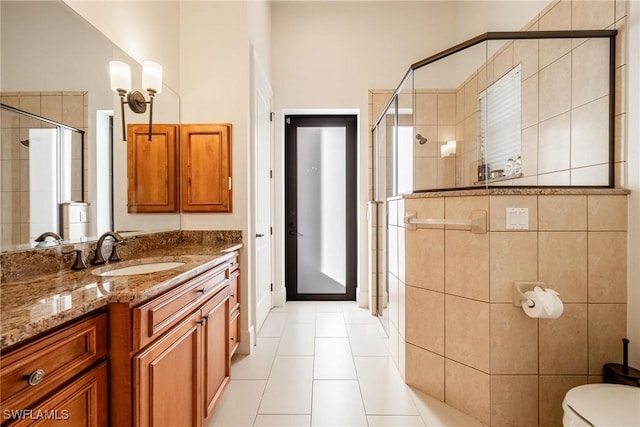 bathroom with toilet, vanity, tile patterned floors, and a shower with shower door