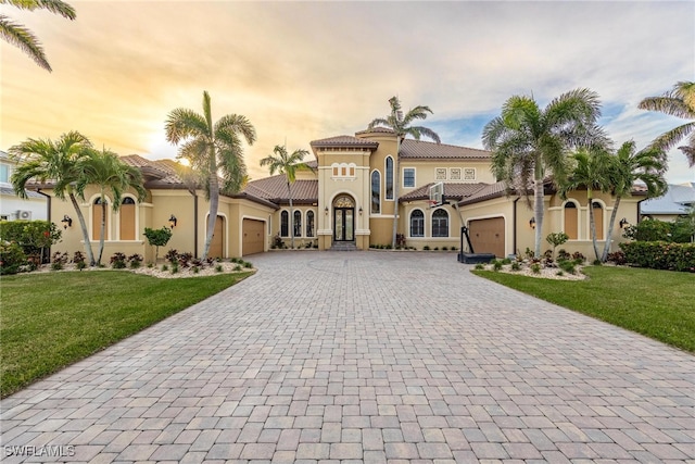 mediterranean / spanish home featuring a yard and a garage