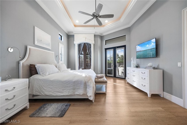 bedroom featuring access to outside, french doors, ceiling fan, a tray ceiling, and light hardwood / wood-style floors