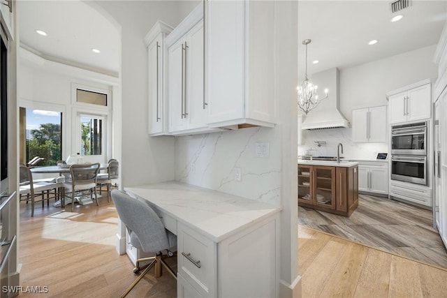 home office featuring a notable chandelier and light hardwood / wood-style floors