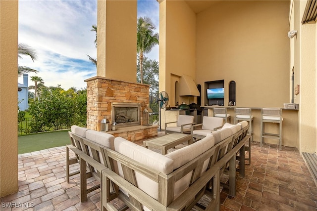 view of patio featuring an outdoor living space with a fireplace and exterior kitchen