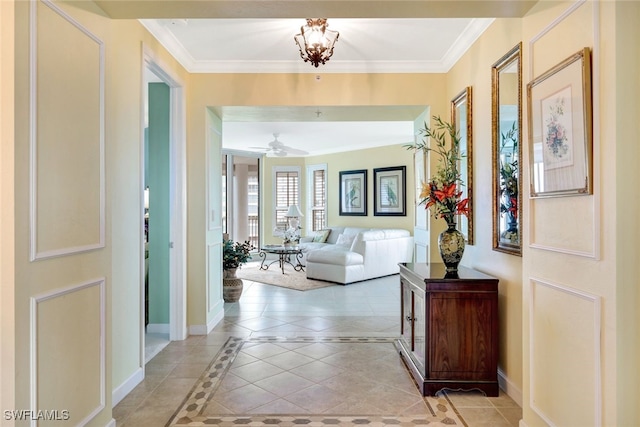 foyer with crown molding, light tile patterned floors, and ceiling fan with notable chandelier