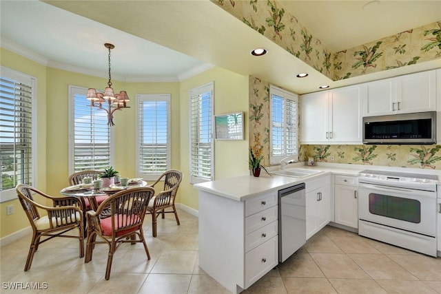 kitchen with white cabinetry, sink, stainless steel appliances, kitchen peninsula, and a chandelier