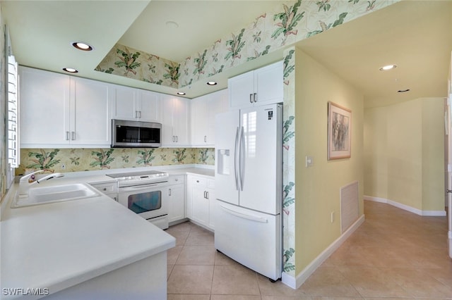 kitchen featuring sink, white cabinets, white appliances, and light tile patterned floors