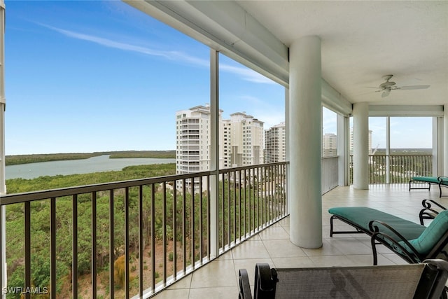 balcony with ceiling fan and a water view