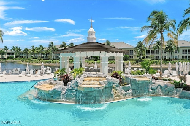 view of pool with a gazebo, pool water feature, and a water view