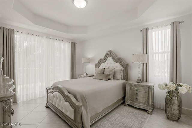 580 El Camino Real Unit 3201, Naples, FL 34119 - bedroom with a tray ceiling and light tile patterned flooring