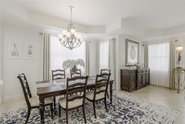 580 El Camino Real Unit 3201, Naples, FL 34119 - dining area with a tray ceiling, a chandelier, and light tile patterned flooring