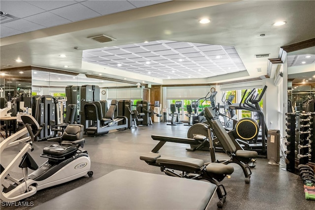 exercise room featuring a tray ceiling and a drop ceiling