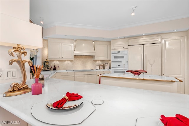 kitchen featuring white double oven, paneled fridge, tasteful backsplash, premium range hood, and kitchen peninsula