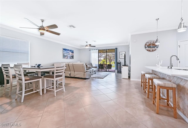 tiled living room with crown molding and sink