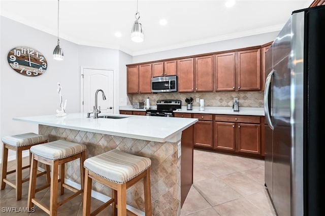 kitchen with a breakfast bar, decorative light fixtures, sink, and appliances with stainless steel finishes