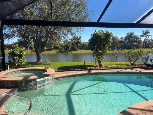 view of pool featuring a lawn, glass enclosure, an in ground hot tub, and a water view