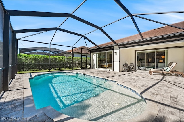 view of pool featuring glass enclosure and a patio