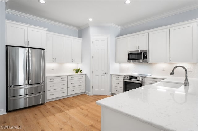 kitchen featuring light stone countertops, light wood-type flooring, stainless steel appliances, sink, and white cabinetry