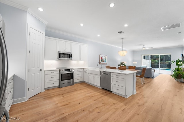 kitchen with kitchen peninsula, stainless steel appliances, white cabinetry, and hanging light fixtures