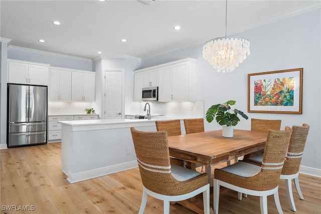 kitchen with kitchen peninsula, white cabinetry, pendant lighting, and appliances with stainless steel finishes