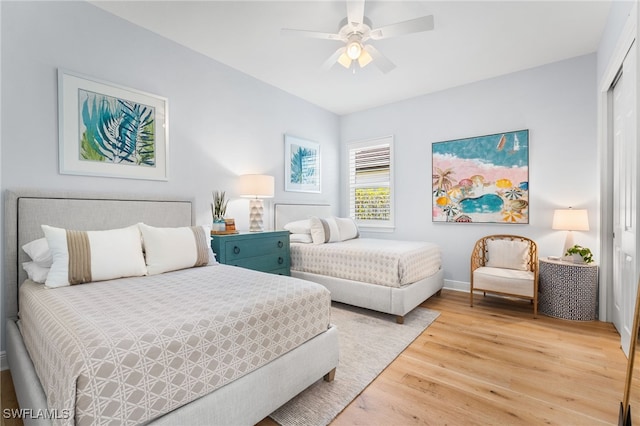 bedroom with a closet, hardwood / wood-style flooring, and ceiling fan