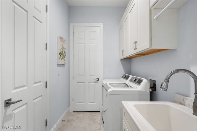 clothes washing area with cabinets, sink, and washing machine and dryer