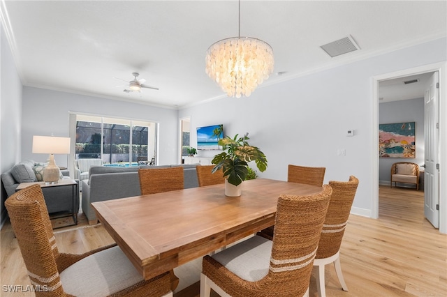 dining area with light hardwood / wood-style floors, ceiling fan with notable chandelier, and ornamental molding