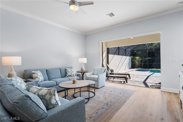 living room featuring ceiling fan, crown molding, and light hardwood / wood-style floors